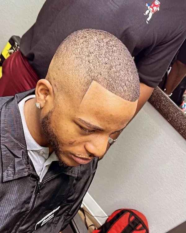 A finished skin fade seen from behind, cut on the academy floor